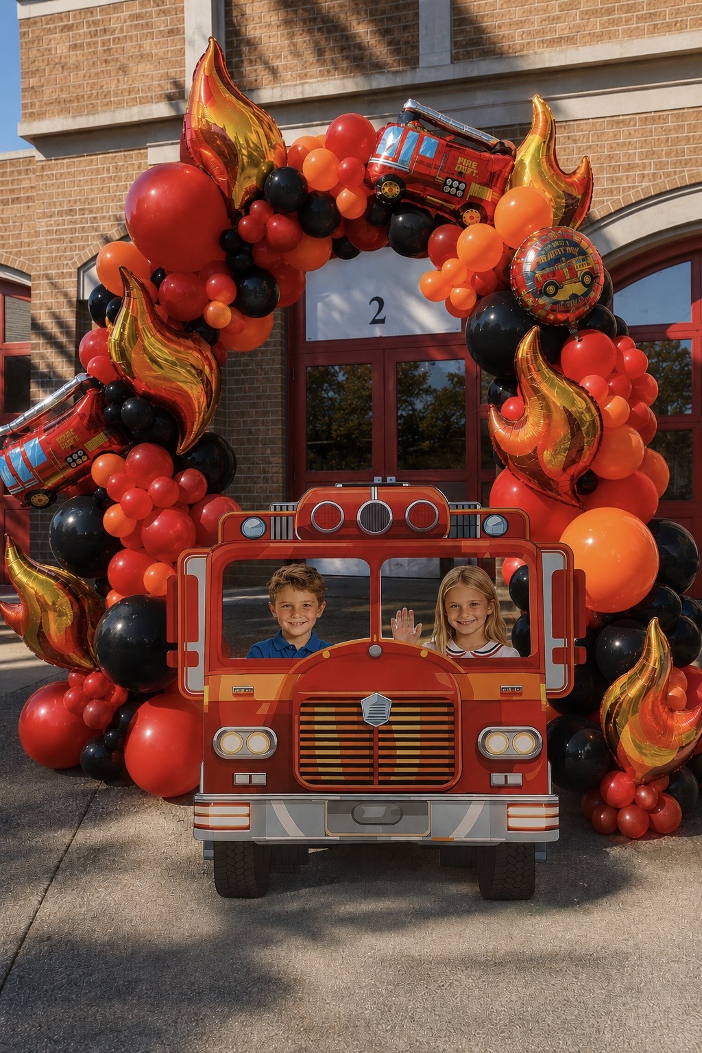 Fire truck photo backdrop with red, orange and black balloon arch and flame foil balloons